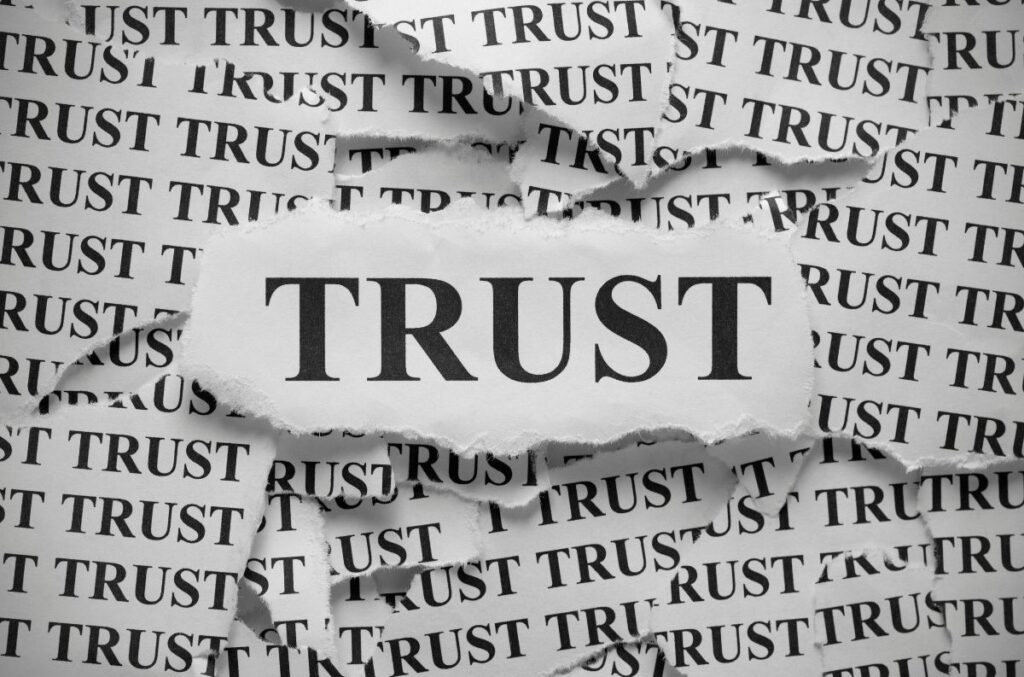 The word “TRUST” prominently displayed in bold among repeated background text, emphasizing the concept of trust standing out within surrounding noise or information.