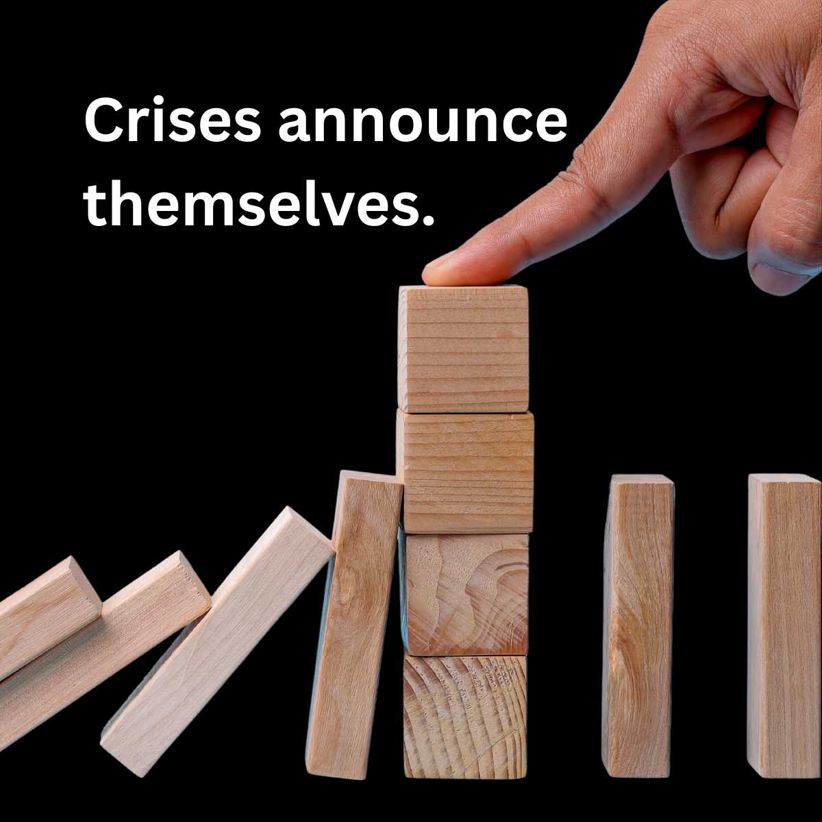 A hand stopping a row of falling wooden domino blocks by holding a stacked cube in place.
