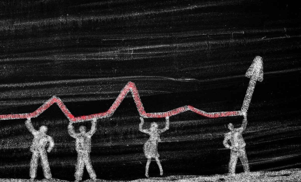 Chalk drawing of people holding up a fluctuating line graph on a blackboard with an upward arrow at the end.