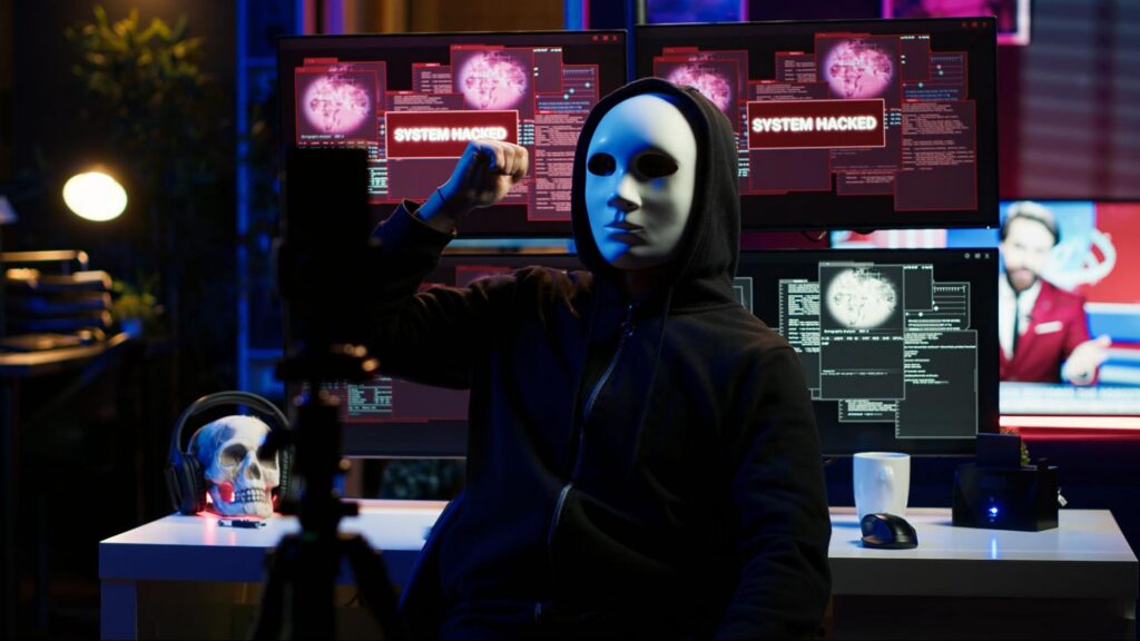 image of a masked man with a knife with computer screens showing 'system hacked' in the background, this image communicates AI espionage